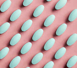 Image showing green pills on pink background