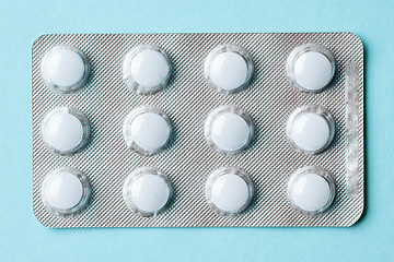 Image showing white pills on blue background