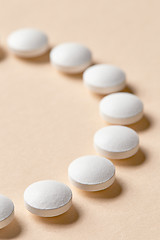 Image showing white pills on beige background