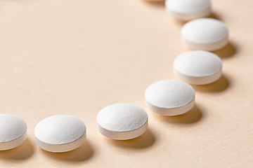 Image showing white pills on beige background