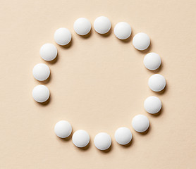 Image showing white pills on beige background