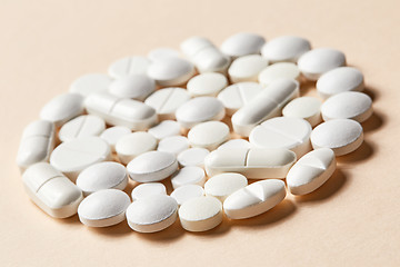 Image showing white pills on beige background