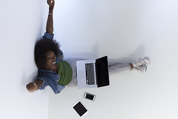 Image showing african american woman sitting on floor with laptop top view