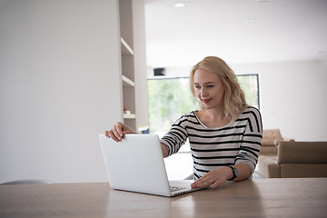 Image showing Young woman with laptop at home