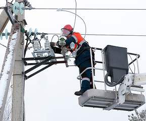 Image showing Electrician connect the wires to the line isolator