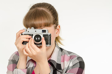 Image showing The girl photographer photographing the old film camera