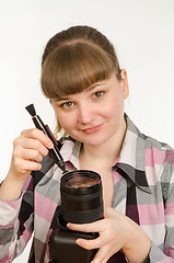 Image showing Photographer cleans front of the lens on the camera, and looked into the frame