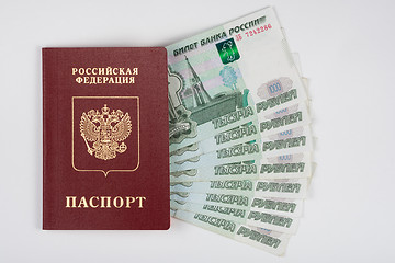 Image showing Passport and money fanned out on a white background