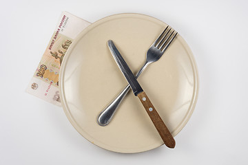 Image showing Empty plate with fork and knife, close is a hundred-ruble note, white background