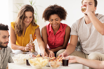 Image showing happy friends with drinks eating pizza at home