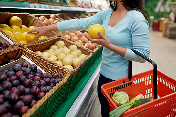 Image showing woman with basket buying pomelo at grocery store