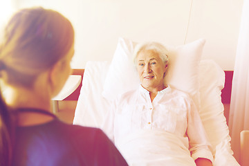 Image showing doctor or nurse visiting senior woman at hospital