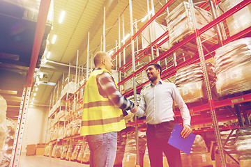 Image showing worker and businessmen with clipboard at warehouse