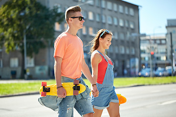 Image showing teenage couple with skateboards on city street