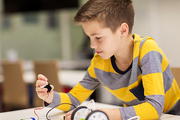 Image showing close up of boy building robot at robotics school