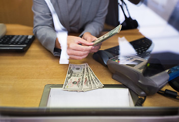 Image showing clerk giving cash money to customer at bank office