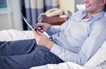 Image showing businessman with tablet pc at hotel room
