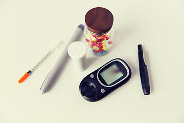 Image showing close up of glucometer, insulin pen and drug pills