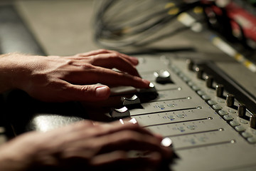 Image showing hands on mixing console in music recording studio