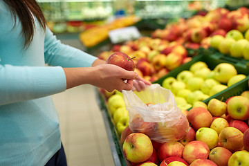 Image showing woman with bag buying apples at grocery store