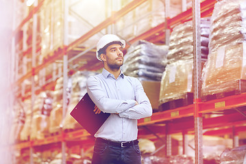 Image showing happy businessman with clipboard at warehouse