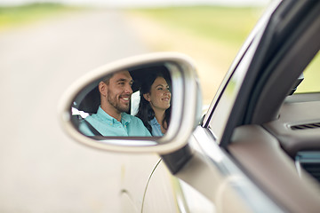 Image showing side mirror reflection of happy couple driving car