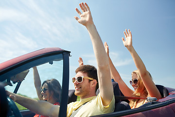 Image showing happy friends driving in cabriolet car at country