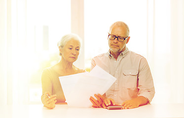 Image showing senior couple with papers and calculator at home