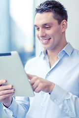 Image showing smiling businessman with tablet pc in office