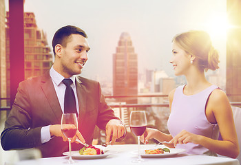 Image showing smiling couple eating main course at restaurant