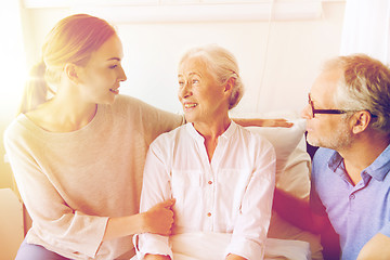 Image showing happy family visiting senior woman at hospital