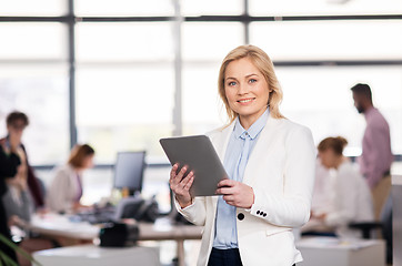 Image showing smiling businesswoman with tablet pc at office