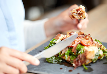 Image showing woman eating prosciutto ham salad at restaurant