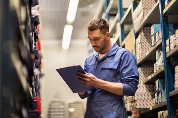 Image showing auto mechanic with clipboard at car workshop