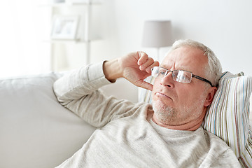 Image showing close up of senior man in glasses thinking at home