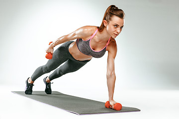 Image showing Beautiful slim brunette doing some stretching exercises