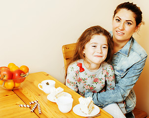 Image showing young mother with daughter on kitchen drinking tea together hugg