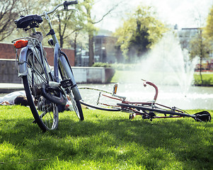 Image showing lifestyle people concept: couple of bicycle on green grass in summer park at fountain