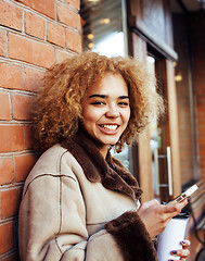 Image showing young pretty african american women drinking coffee outside in c