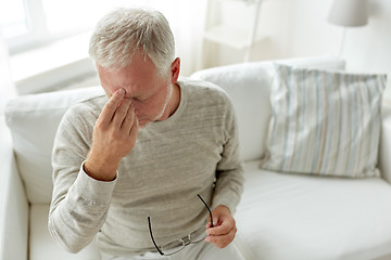 Image showing senior man suffering from headache at home