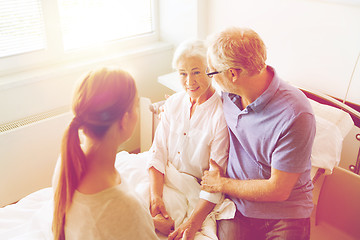 Image showing happy family visiting senior woman at hospital