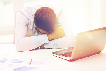 Image showing businessman with laptop and papers in office