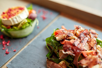 Image showing prosciutto ham salad on stone plate at restaurant