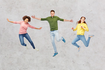 Image showing smiling young man jumping in air