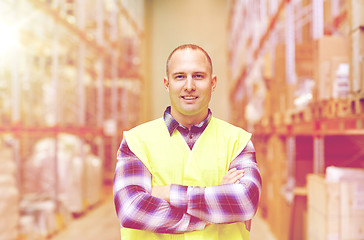 Image showing happy man in reflective safety vest at warehouse