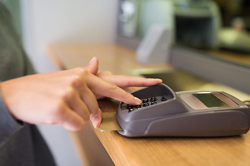 Image showing close up of hand entering code to money terminal