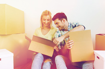 Image showing smiling couple with many boxes moving to new home