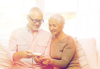 Image showing happy senior couple with camera at home