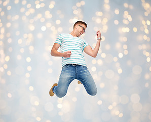 Image showing happy man jumping and playing imaginary guitar