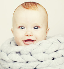 Image showing little cute red head baby in scarf all over him close up isolate